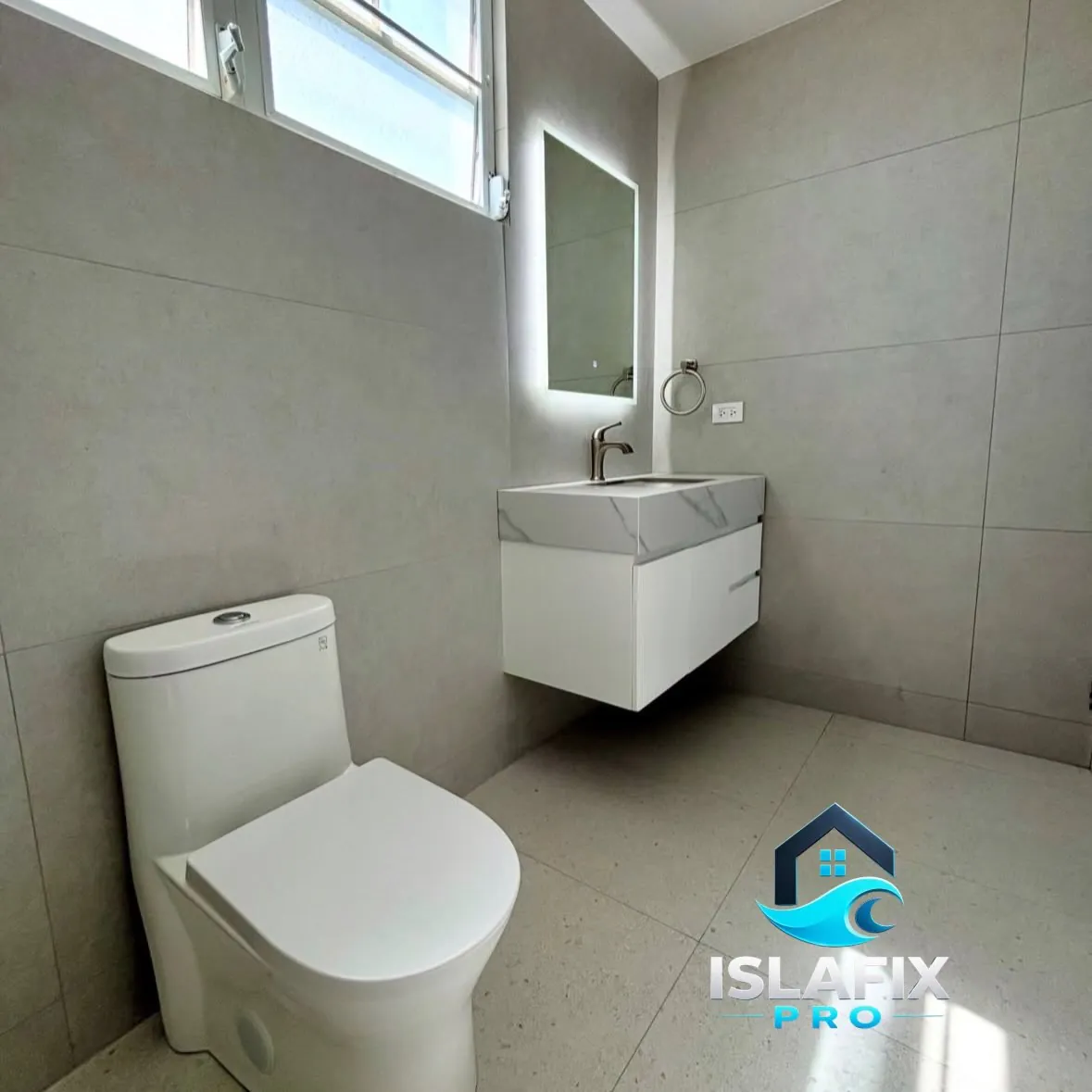 Baño remodelado con revestimiento grande, vanidad flotante y espejo con luz